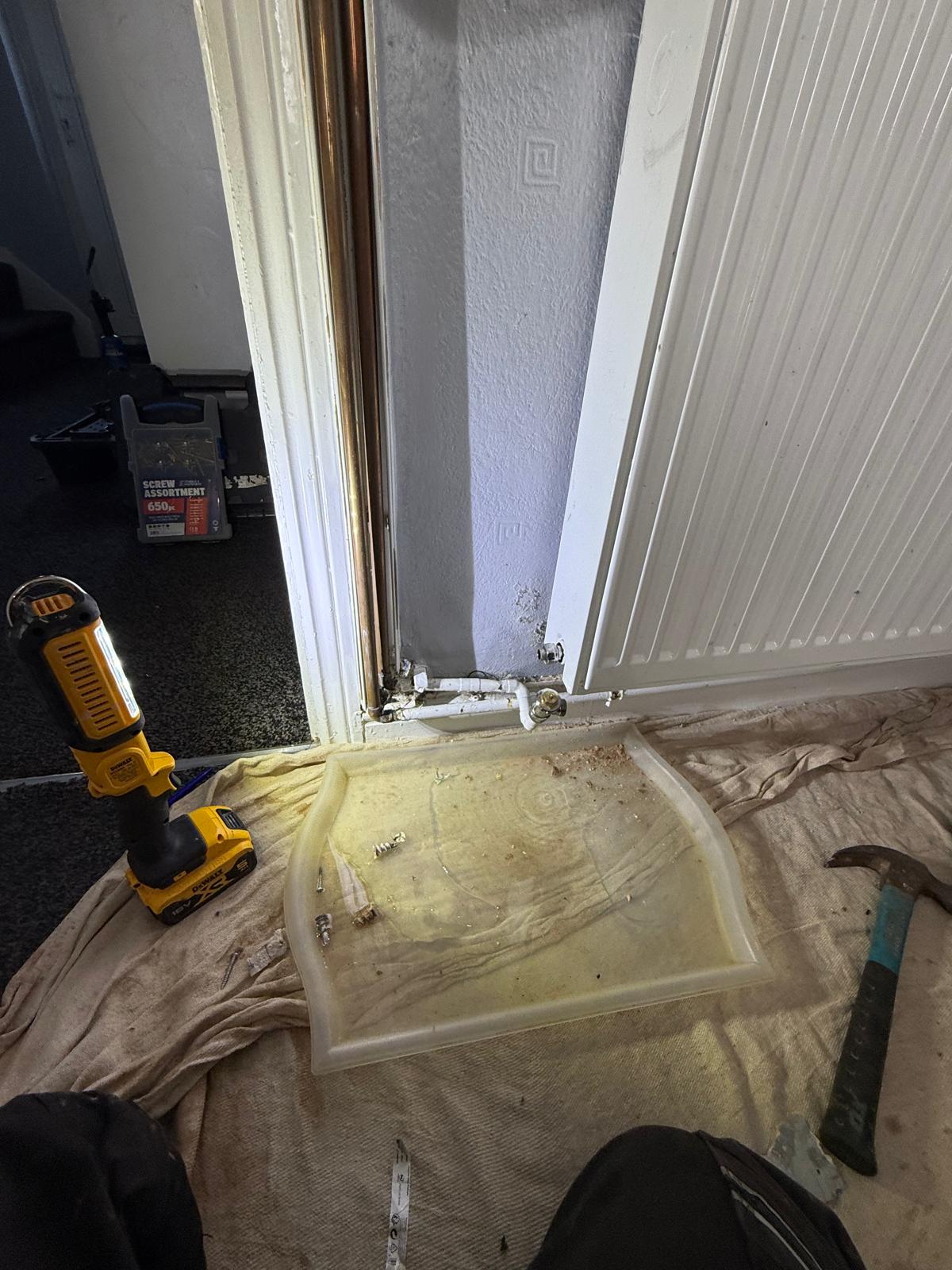 Radiator pipe leak repair in progress in Walsall with dust sheet and tools laid out